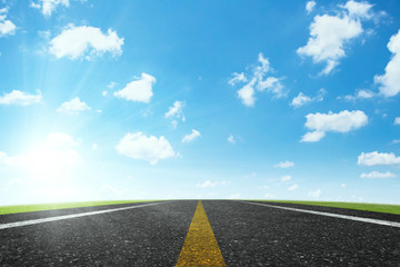 Asphalt road and blue sky clouds at sunrise. Concept for success in the future goal and passing time. Happy new year