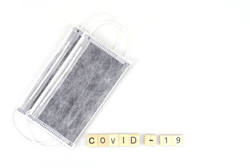 Covid 19 wooden character and surgical mask in the background , isolated on white background