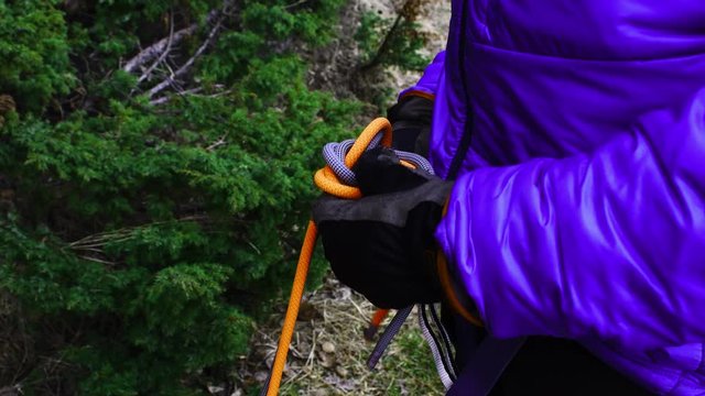 Climber hithing eight-knot on double rope climbing system. Knot links climber in safety system anf climbing partner.