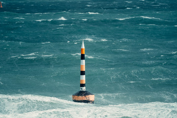 A once in a decade storm hitting the iconic Cottesloe bollard. Huge waves crash against the bollard with heavy rain pouring down. 