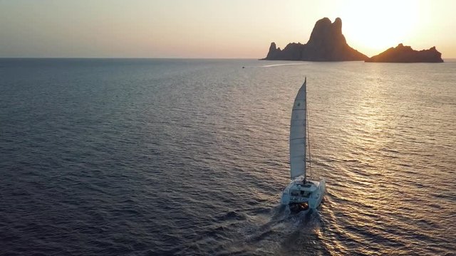 Sailing into the beautiful sunset of Es Vedrà, Ibiza // drone 4K
