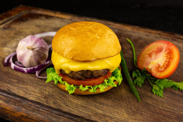 Hamburger artesanal grelhado com quejo, alface, tomate, alho, cebola e bacon.