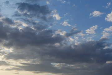 Natural background. White and gray clouds in the blue evening sky