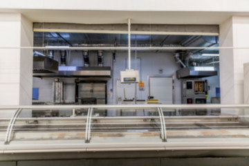 Empty cooking department at supermarket. Appliances, ovens and cutting tables with counters. Blurred.