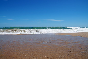 empty sea sandy shore, white waves and sky