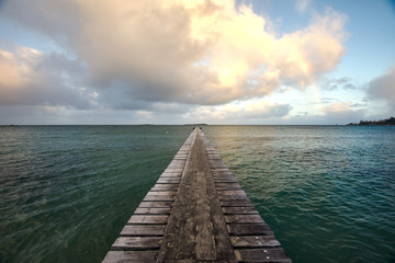 wooden jetty in the sea during sunrise