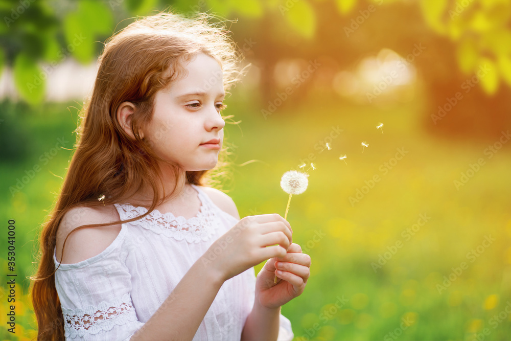 Wall mural Little curly girl with spring flower in sunset light.