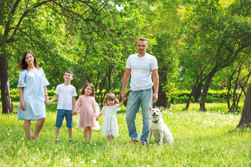 Obraz premium Happy beautiful big family together mother, father, children and dog walking on a Sunny summer day