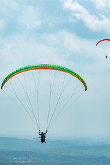 Outdoor city green hill scenery and paragliding