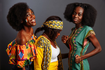 Three young beautiful African fashion models have fun and laughing in traditional dress. Women from...