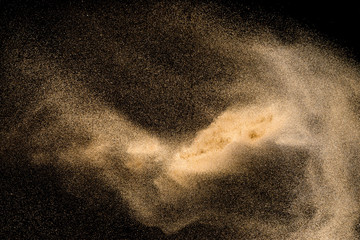 Dry river sand with stone explosion. Yellow colored sand splash agianst dark background.