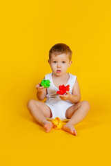 a little boy sits and tries to connect the details from an educational game such as a pyramid