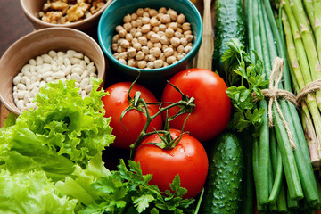 Organic fruits, vegetables, legumes on wooden background