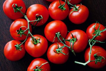 Tomatos on dark wooden background. Healthy food. Dietetic foods. Copy space