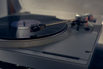 The vinyl needle reads the music from the record on a vinyl player. Old school. musical atmosphere. Old player and analog music. subject photo.