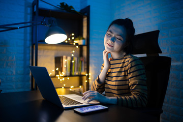 Asian woman working on a laptop overtime and scratching her hands at home. WFH. Work from home for...