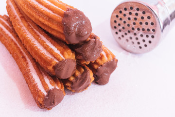 Churros stuffed with chocolate sauce on white background