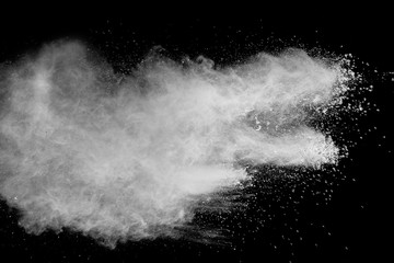 Bizarre forms of  white powder explosion cloud against dark background. Launched white particle splash on black background