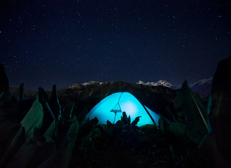 Fototapeta premium Glowing tent camping in the Night Mountains