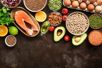 Ingredients for a healthy balanced diet: fruits, vegetables, legumes, fish, eggs, seeds. Concept of healthy eating and clean food. Top view, flat lay, copy space.