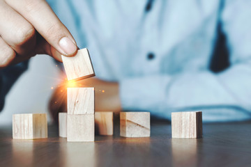 Business men are stacking wooden blocks stacking as step stair on table. New normal Business development Decide and choose, Business concept for growth success process, Vintage tone.Copy space