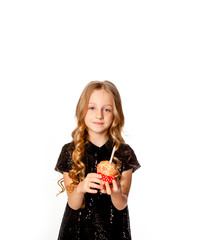 cute girl in a black sequin dress holds a birthday cupcake
