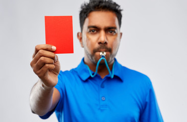 sport, caution, game and football concept - indian referee whistling and showing red penalty card...