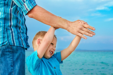 hands of happy parent and child at sea greece background