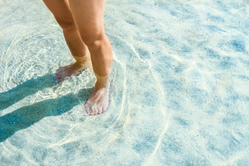 beautiful legs on the sand by the Greek sea