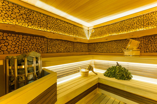 modern beautiful sauna with brooms and sauna accessories, a dry steam room with stones and saddles with beautiful lighting