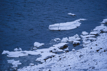 Verschneite Küste am Fluss