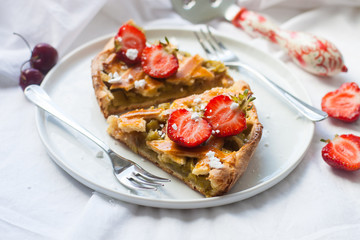 Slices of strawberry and rhubarb pie on white plate. Top view. Homemade summer bakery.