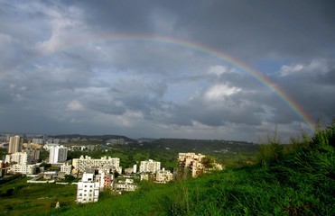 Beautiful landscape of hill and town with rainbow