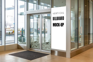 Mock up vertical signboard on glass wall front of entrance
