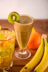 Kiwi fruit tropical mixed drink, cocktails served on light wooden table.