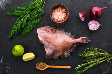 Raw crimson sea bream with spice and herbs on black background