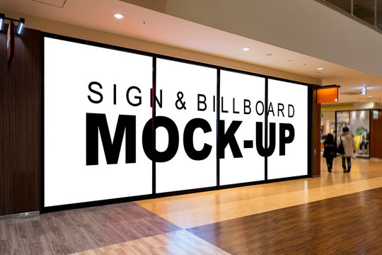 Mock up blank billboard on glassy showcase in shopping mall