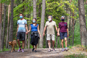 Familie beim Spaziergang im Wald mit Mundschutz