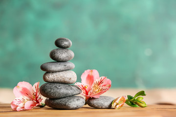 Stack of spa stones and flowers on table