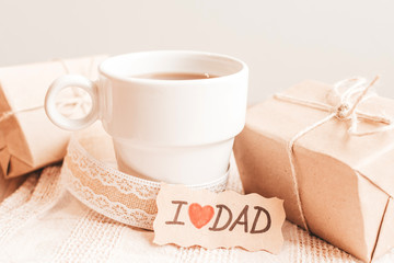 Gift box with a tag, cup of coffee or tea. Father's day or birthday concept.