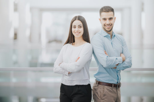 Smiling customer representatives standing in a bright office corridor at work