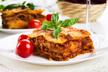 Piece of tasty hot lasagna with red wine.. - obrazy, fototapety, plakaty