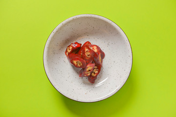 Tasty oriental sweets, dessert churchkhela, cut and served in a white plate over bright green background.