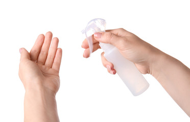 Woman using sanitizer on white background