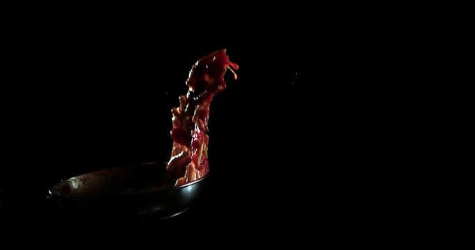 Slow motion ravioli and penne rigati pasta on a cooking pan