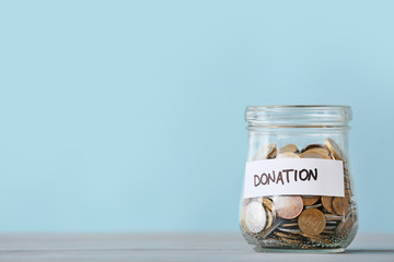 Jar with coins on table. Donation concept