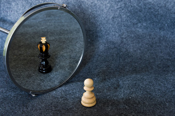 White chess pawn reflected as a black king.