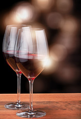 two glasses with deep red wine on dark wood