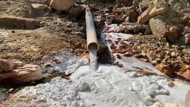 Front view of polluted water with cyanide draining from an old pipe in Rosia Montana