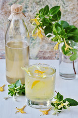 cold drink of lemonade with syrup  honeysuckle. Syrup of  flowers honeysuckle. Unusual drinks from...